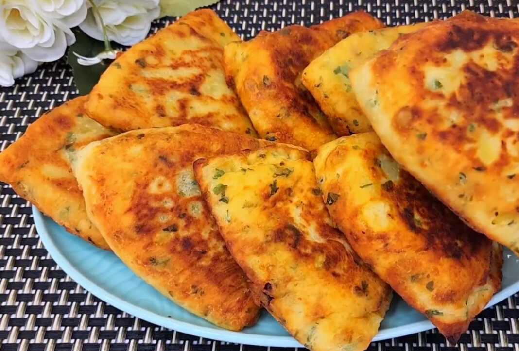 Χρυσαφένιες πατατοκιμαδόπιτες τηγανισμένες, ανοιγμένες στη μέση να φαίνεται η πλούσια γέμιση κιμά με μυρωδικά.