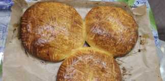 Στρογγυλές χρυσαφένιες πίτες με παραδοσιακά σχέδια από πιρούνι στην επιφάνεια, τοποθετημένες σε λαδόκολλα.