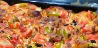 Ατομικά Πιτσάκια Ρολό: Η Πιο Πρωτότυπη και Νόστιμη Πίτσα του Σαββάτου! Μια σειρά από πιτσάκια σε σχήμα ρολού μέσα σε ταψί, με λιωμένο τυρί, σάλτσα ντομάτας και κομμάτια ζαμπόν να ξεχειλίζουν.