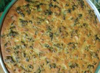 Ένα ταψί με παραδοσιακό πλαστό, με χρυσαφένια κρούστα από καλαμποκάλευρο και πλούσια πράσινη γέμιση από σπανάκι και μυρωδικά.