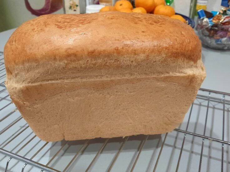 Ένα καρβέλι σταρένιο ψωμί φόρμας με χρυσαφένια κρούστα, τοποθετημένο πάνω σε ξύλινη επιφάνεια.