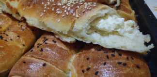 Σειρές από χρυσαφένια, αφράτα ρολάκια με τυρί, πασπαλισμένα με σουσάμι, μόλις βγήκαν από τον φούρνο.