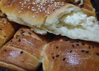 Σειρές από χρυσαφένια, αφράτα ρολάκια με τυρί, πασπαλισμένα με σουσάμι, μόλις βγήκαν από τον φούρνο.