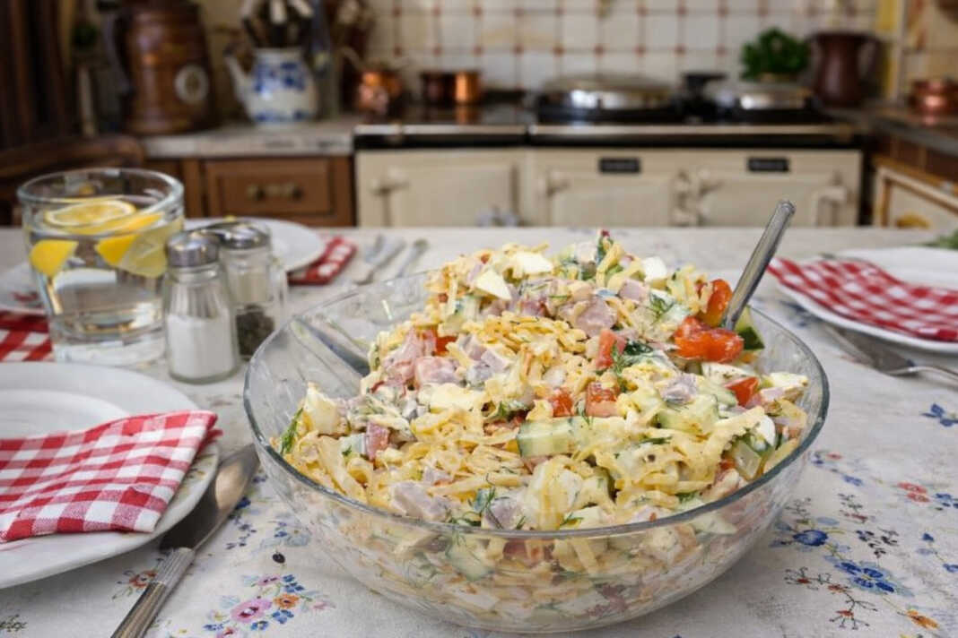 Μια πολύχρωμη σαλάτα με κυβάκια αλλαντικών, τυριού, τομάτας και πιπεριάς, ανακατεμένη με κρεμώδη σάλτσα και φρέσκα μυρωδικά.