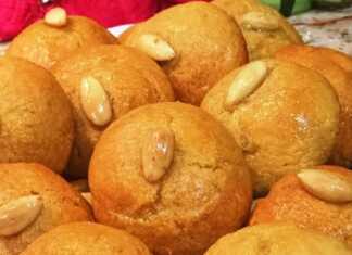 Μια πιατέλα με στρογγυλά σιροπιαστά σεκέρ παρέ, το καθένα διακοσμημένο με ένα ολόκληρο ασπρισμένο αμύγδαλο στο κέντρο.