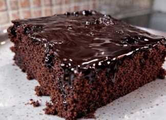 Ένα κομμάτι ζουμερής σοκολατόπιτας με γυαλιστερό σιρόπι σοκολάτας να τρέχει στις πλευρές του, σερβιρισμένο σε ένα πιάτο.