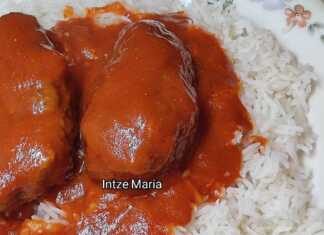 Ένα πιάτο με μελωμένα σουτζουκάκια σε πλούσια κόκκινη σάλτσα, σερβιρισμένα πάνω σε αφράτο ρύζι μπασμάτι.