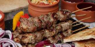 Ζουμερά χοιρινά σουβλάκια που ψήνονται πάνω σε λευκά κάρβουνα, με το λίπος να στάζει και τον καπνό να αναδεικνύει τα αρώματα της ρίγανης.