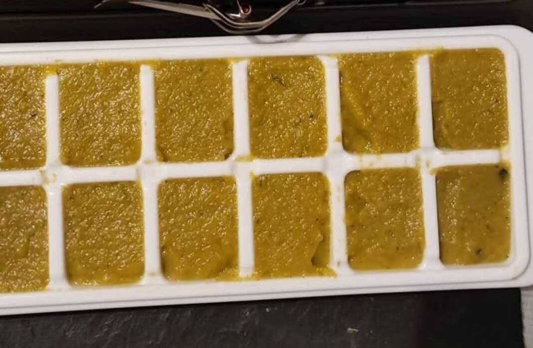 Μια σειρά από ομοιόμορφα τετράγωνα σπιτικού ζωμού λαχανικών πάνω σε λαδόκολλα, με φρέσκα βότανα και λαχανικά να τα περιβάλλουν.