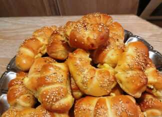 πολλά χρυσαφένια τυροπιτάκια σε σχήμα κρουασάν, πασπαλισμένα με σουσάμι.