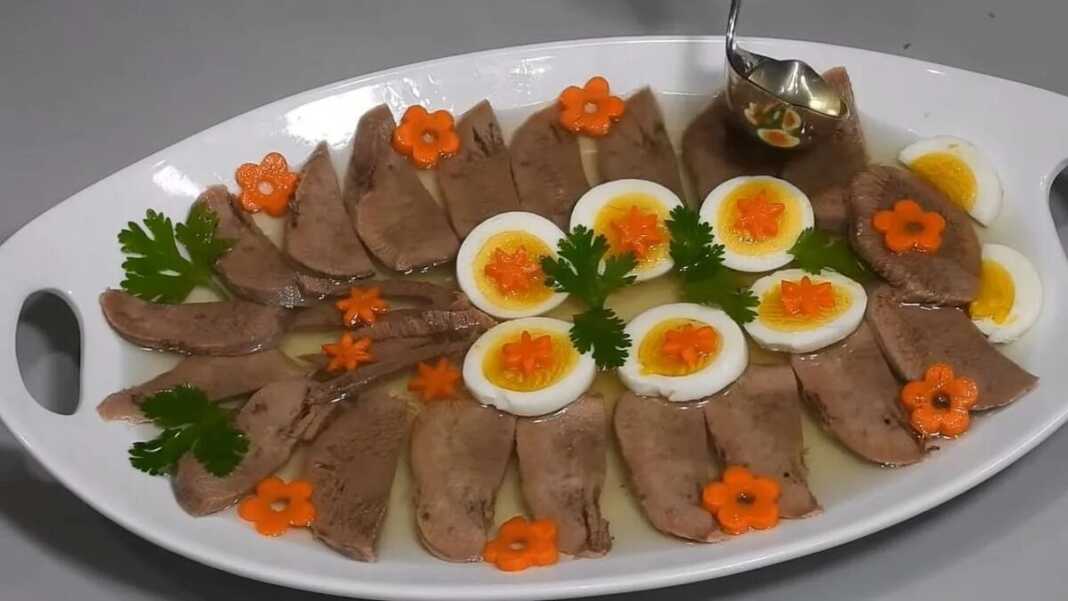 Λεπτές φέτες μοσχαρίσιας γλώσσας μέσα σε διαυγές ζελέ, διακοσμημένες με φέτες αυγού, αγγουράκι τουρσί και φρέσκο μαϊντανό.