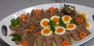 Λεπτές φέτες μοσχαρίσιας γλώσσας μέσα σε διαυγές ζελέ, διακοσμημένες με φέτες αυγού, αγγουράκι τουρσί και φρέσκο μαϊντανό.