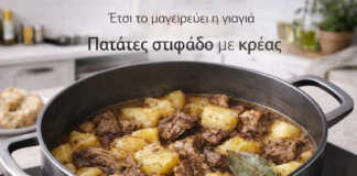 Μια βαθιά κατσαρόλα με σιγομαγειρεμένο μοσχάρι και μεγάλες κομμένες πατάτες μέσα σε πλούσιο, μελωμένο ζουμί με φύλλα δάφνης.