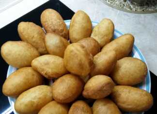 Μια στοίβα από χρυσαφένια, φουσκωτά και αέρινα ντονατσάκια πάνω σε μια πιατέλα, έτοιμα για σερβίρισμα.