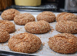 Σειρά από αφράτα χρυσαφένια κουλούρια Θεσσαλονίκης με πλούσιο σουσάμι πάνω σε λαδόκολλα