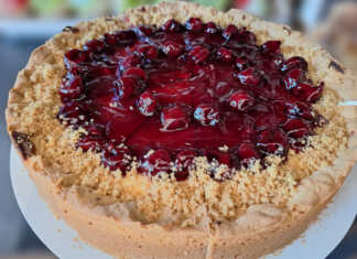 Πλούσιο κομμάτι ψητού cheesecake με παχιά στρώση κρέμας και κατακόκκινο γλυκό του κουταλιού βύσσινο να τρέχει στις πλευρές