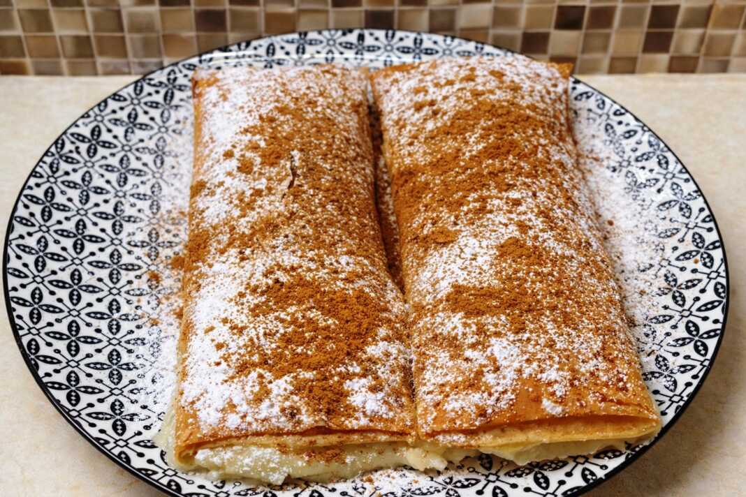 Χρυσαφένιες ατομικές μπουγάτσες σε σχήμα φακέλου πασπαλισμένες με μπόλικη άχνη ζάχαρη και κανέλα