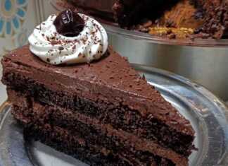 Μια επιβλητική τούρτα Μπλάκ Φόρεστ καλυμμένη με γκανάζ σοκολάτας, ροζέτες σαντιγί και ολόκληρα βύσσινα.