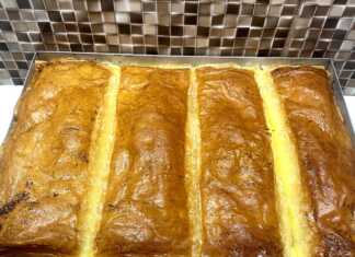 Ταψί με χρυσαφένιο, σιροπιασμένο γαλακτομπούρεκο κομμένο σε τετράγωνα κομμάτια.