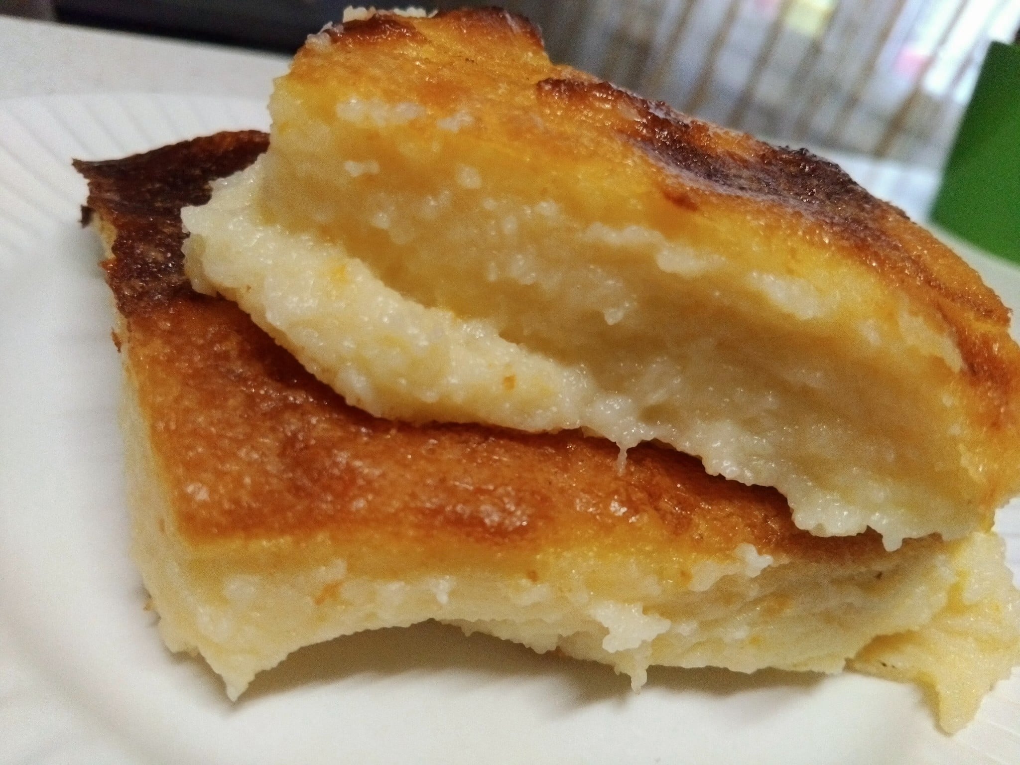 Μια χρυσαφένια παραδοσιακή γαλατόπιτα πασπαλισμένη με άχνη ζάχαρη και κανέλα μέσα στο ταψί της