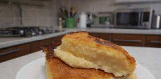 Μια χρυσαφένια παραδοσιακή γαλατόπιτα πασπαλισμένη με άχνη ζάχαρη και κανέλα μέσα στο ταψί της