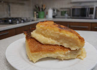 Μια χρυσαφένια παραδοσιακή γαλατόπιτα πασπαλισμένη με άχνη ζάχαρη και κανέλα μέσα στο ταψί της