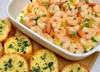 Ζουμερές γαρίδες στον φούρνο μέσα σε πλούσιο σκορδοβούτυρο, γαρνιρισμένες με φρέσκα μυρωδικά και φέτες λεμονιού