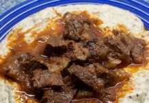 Ένα πλούσιο πιάτο Χουνκιάρ Μπεγιεντί με τρυφερό κοκκινιστό μοσχάρι πάνω σε βελούδινο λευκό πουρέ μελιτζάνας, γαρνιρισμένο με φρέσκο μαϊντανό.