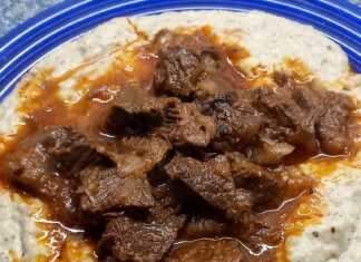 Ένα πλούσιο πιάτο Χουνκιάρ Μπεγιεντί με τρυφερό κοκκινιστό μοσχάρι πάνω σε βελούδινο λευκό πουρέ μελιτζάνας, γαρνιρισμένο με φρέσκο μαϊντανό.