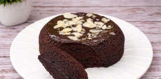 Ένα ζουμερό σοκολατένιο μάφιν με γλάσο σοκολάτας που αχνίζει μέσα σε μια μικρή φόρμα.