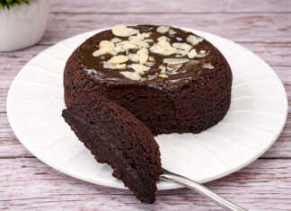 Ένα ζουμερό σοκολατένιο μάφιν με γλάσο σοκολάτας που αχνίζει μέσα σε μια μικρή φόρμα.