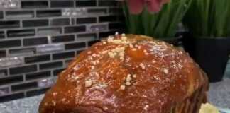 Ένα ψηλό και αφράτο κέικ με κεφίρ, περιχυμένο με χρυσαφένια σπιτική καραμέλα και πασπαλισμένο με ξηρούς καρπούς.