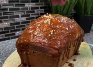 Ένα ψηλό και αφράτο κέικ με κεφίρ, περιχυμένο με χρυσαφένια σπιτική καραμέλα και πασπαλισμένο με ξηρούς καρπούς.