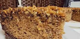 Ένα ζουμερό κομμάτι κέικ μπακλαβά με πλούσια στρώση καραμελωμένων ξηρών καρπών στην κορυφή και χρυσαφένιο σιρόπι.