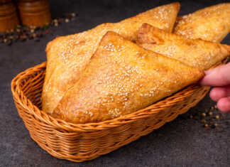 Τραγανά και χρυσαφένια κοτοπιτάκια σφολιάτας με σουσάμι σε σειρά πάνω σε ταψί