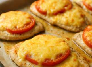 Ψητά φιλετάκια κοτόπουλου καλυμμένα με λιωμένο τυρί, φέτες ντομάτας και χρυσή κρούστα.