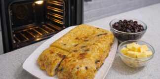 Χρυσαφένια μακαρονοπιτα φούρνου κομμένα σε κομμάτια πασπαλισμένα με ζάχαρη και γεμάτα σταφίδες