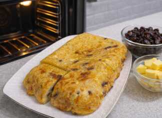 Χρυσαφένια μακαρονοπιτα φούρνου κομμένα σε κομμάτια πασπαλισμένα με ζάχαρη και γεμάτα σταφίδες