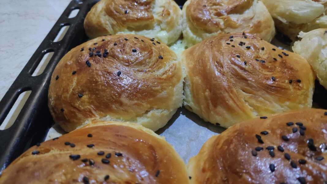 Χρυσαφένια μαλακά και νόστιμα ψωμάκια με τυρί που φαίνονται οι στρώσεις τους, πασπαλισμένα με σουσάμι