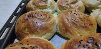 Χρυσαφένια μαλακά και νόστιμα ψωμάκια με τυρί που φαίνονται οι στρώσεις τους, πασπαλισμένα με σουσάμι
