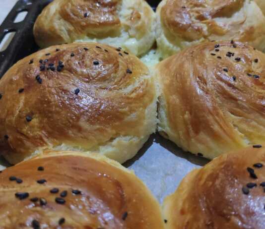 Χρυσαφένια μαλακά και νόστιμα ψωμάκια με τυρί που φαίνονται οι στρώσεις τους, πασπαλισμένα με σουσάμι