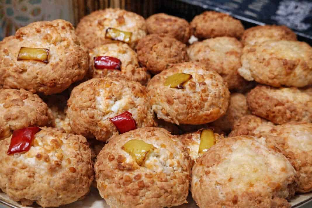 Χρυσαφένια αλμυρά μπισκότα με κεφαλοτύρι και γεμιστά με φέτα και πολύχρωμες πιπεριές πάνω σε λαδόκολλα