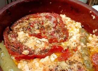 Ένα πήλινο σκεύος με λιωμένη φέτα, ντομάτα και καυτερή πιπεριά, πασπαλισμένο με μπόλικη ρίγανη.