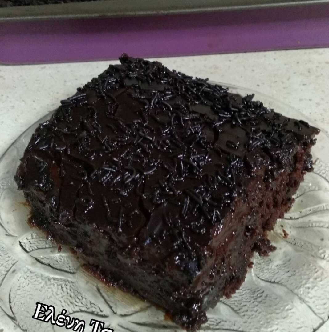 Λαχταριστό κομμάτι νηστίσιμης σοκολατόπιτας με γυαλιστερό γλάσο και πλούσιο σιρόπι