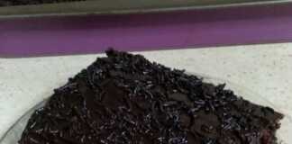 Λαχταριστό κομμάτι νηστίσιμης σοκολατόπιτας με γυαλιστερό γλάσο και πλούσιο σιρόπι