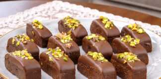 Σειρά από σοκολατένια παστάκια ψυγείου, καλυμμένα με λιωμένη σοκολάτα γάλακτος και πασπαλισμένα με πράσινο φυστίκι Αιγίνης.