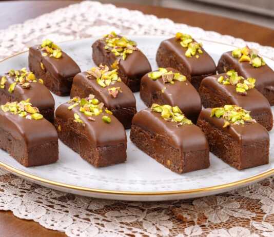 Σειρά από σοκολατένια παστάκια ψυγείου, καλυμμένα με λιωμένη σοκολάτα γάλακτος και πασπαλισμένα με πράσινο φυστίκι Αιγίνης.