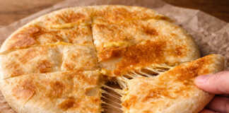 Χρυσαφένιο πατατόψωμο στο τηγάνι που κόβεται στη μέση και τρέχει λιωμένη μοτσαρέλα