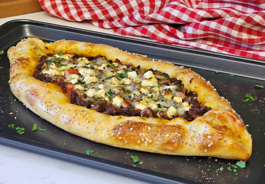 πεϊνιρλί σε σχήμα βάρκας με πλούσιο κιμά, λιωμένα τυριά και σουσάμι στην κόρα