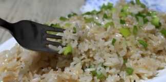 Ένα πιάτο με λαχταριστό, σπυρωτό ρύζι αρωματισμένο με βότανα, όπου κάθε κόκκος φαίνεται ξεχωριστός και καλομαγειρεμένος.